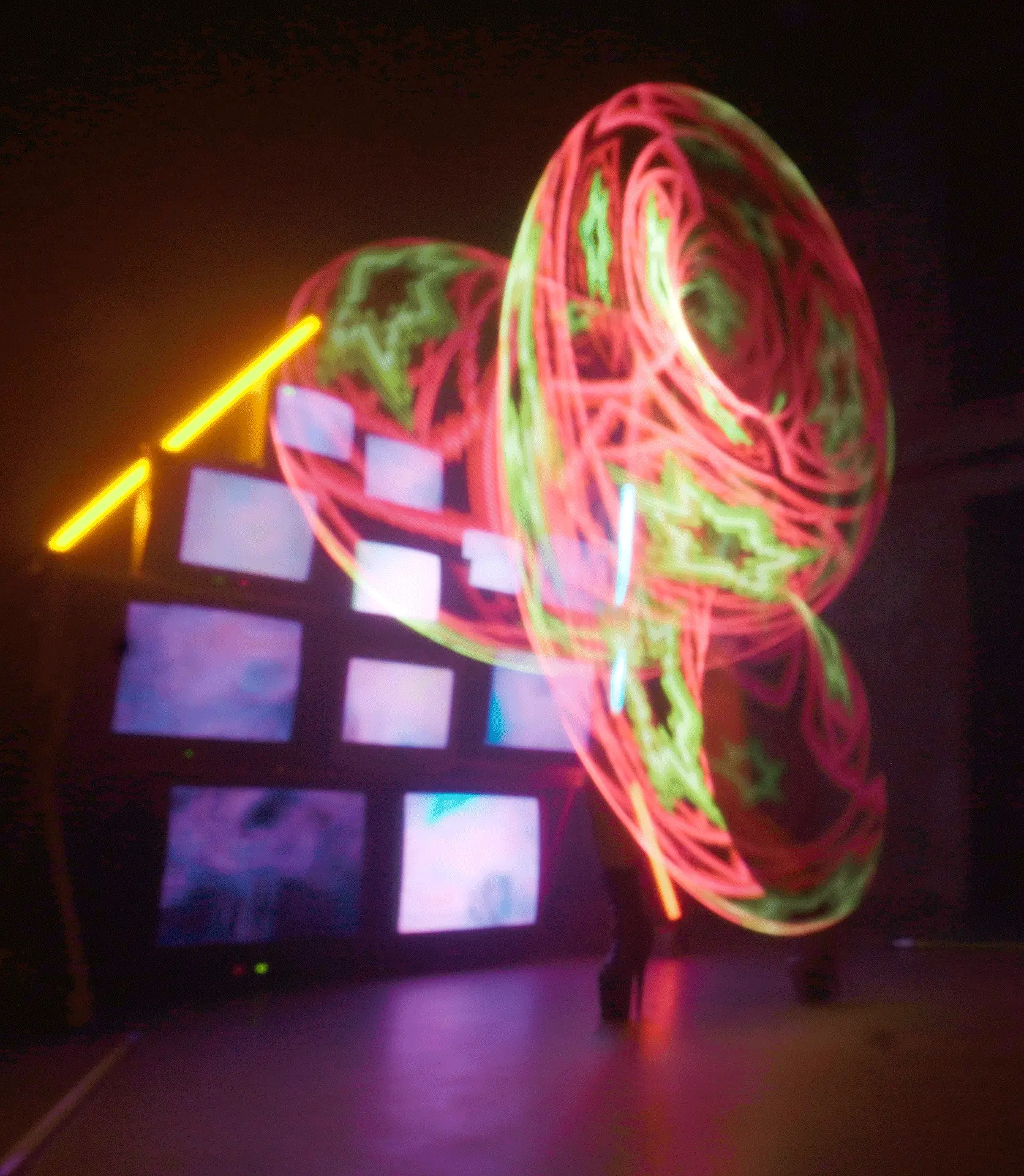 Langzeit Belichtung LED Show Hoop, Zirkus Act, Licht Installation mit CRT TVs und Neon Röhren im Hintergrund