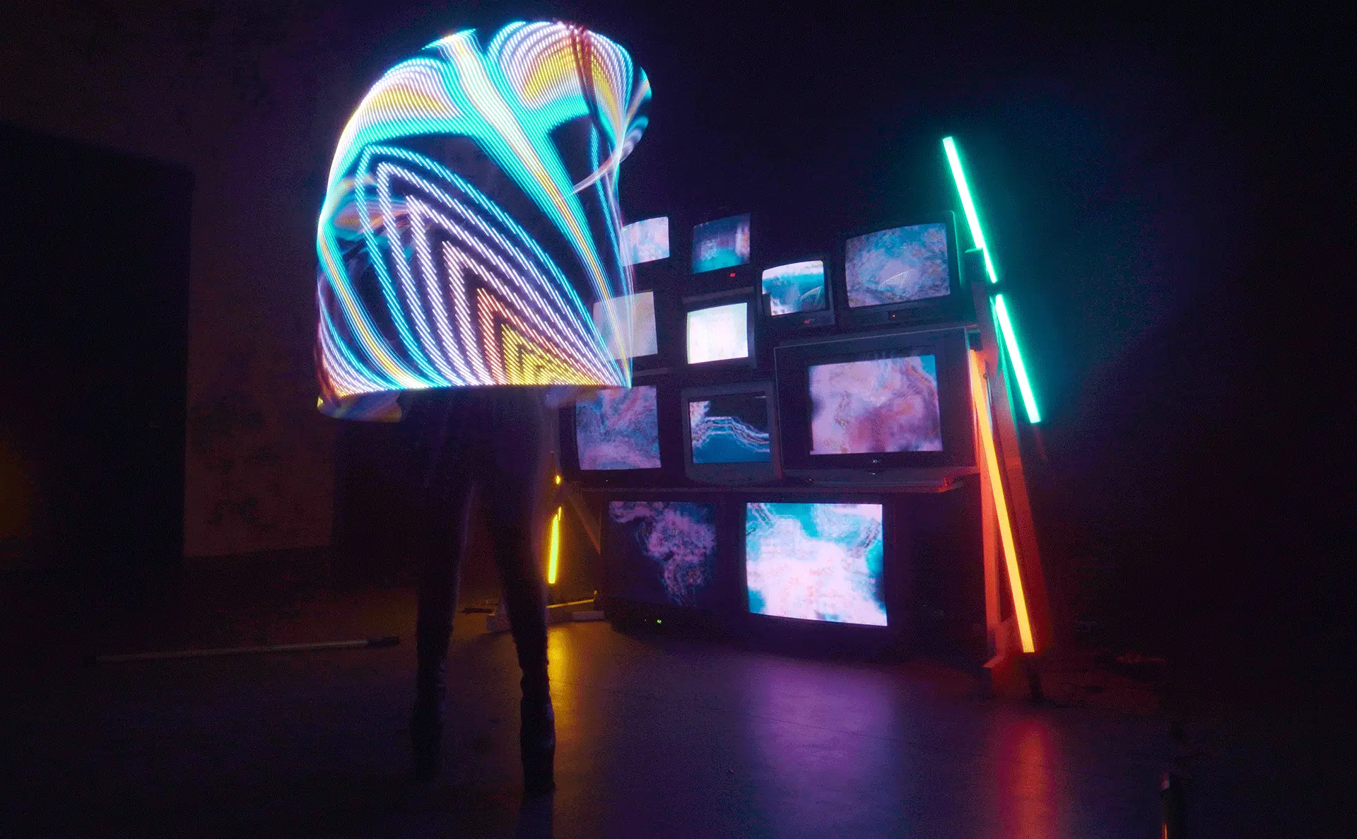 Langzeit Belichtung LED Show Hoop, Zirkus Act, Licht Installation mit CRT TVs und Neon Röhren im Hintergrund