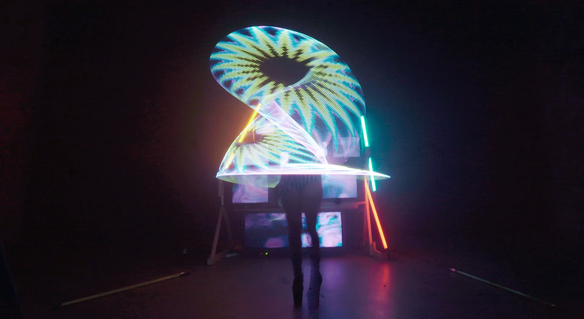 Langzeit Belichtung LED Show Hoop, Zirkus Act, Licht Installation mit CRT TVs und Neon Röhren im Hintergrund